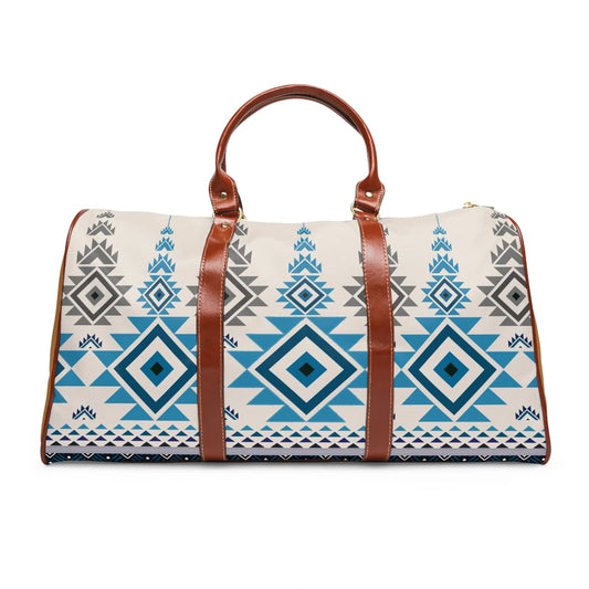 White duffel bag with blue and gray tribal geometric patterns and brown leather handles