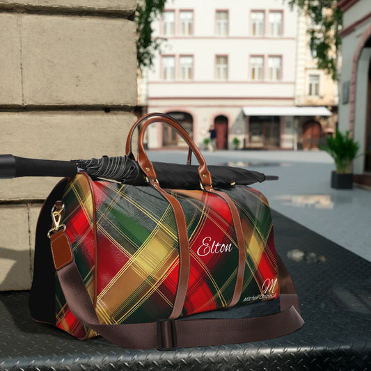 Colorful plaid travel bag with brown leather handles and strap, personalized with name Elton, and a black umbrella